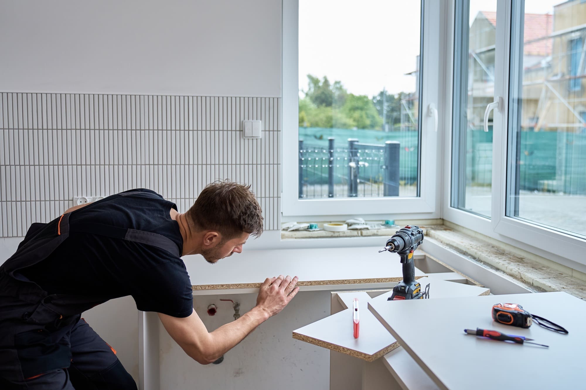 Man installing kitchen countertop during home renovation project
